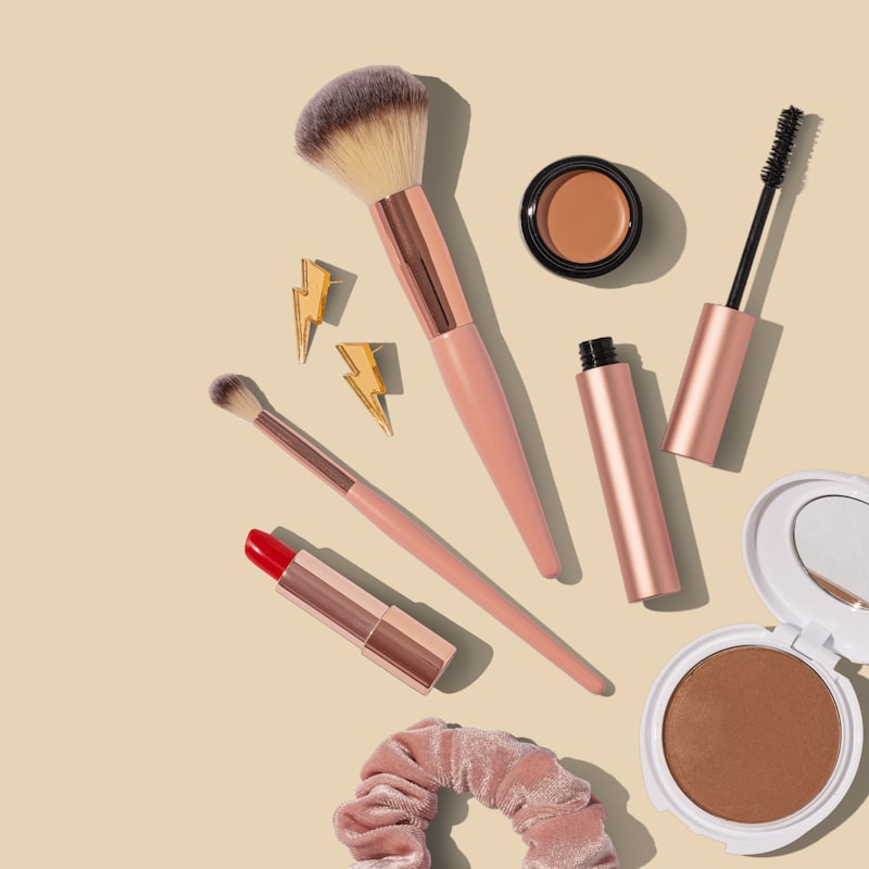 Soft pink and rose gold makeup brush set on warm neutral background